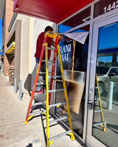 worker installing signage in Austin