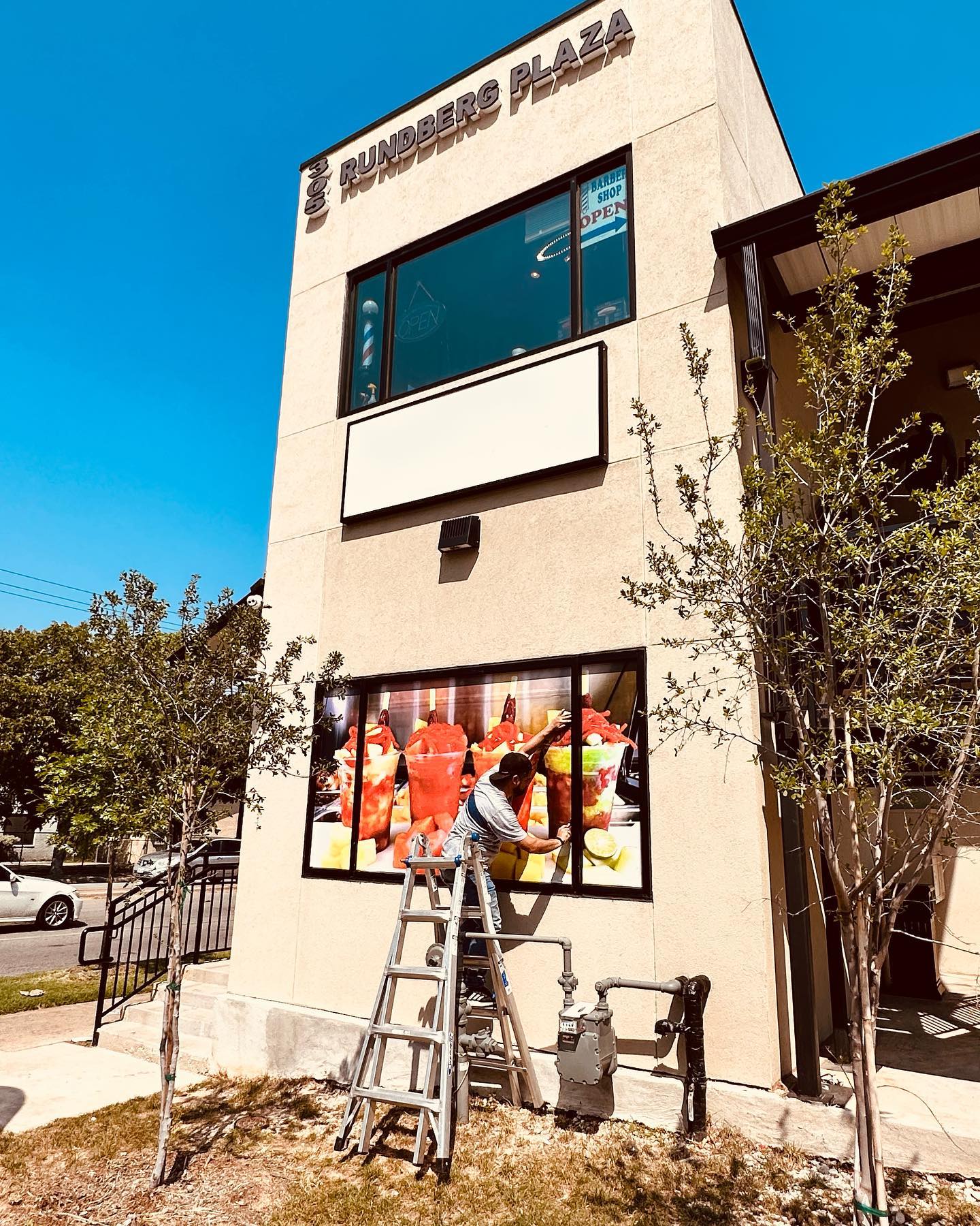 worker installing signage outside commercial building