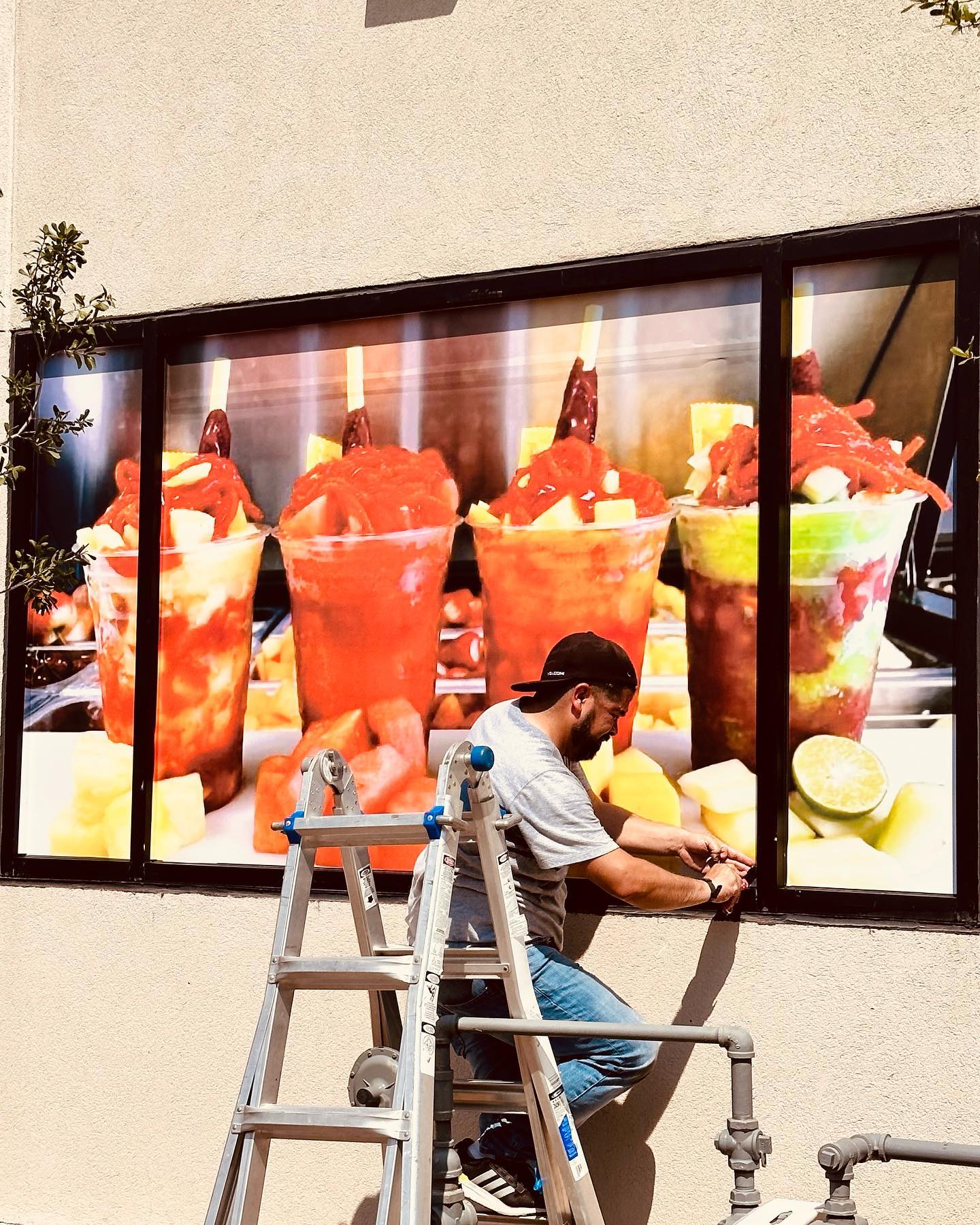 worker installing fruit cup signage